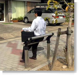 写真：サポーターに腰掛けて休憩している男性