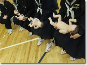 写真：生命誕生「いのちについて考える　生命誕生、そしてつながり」胎児人形を抱っこする中学生たち