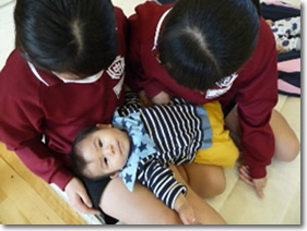 写真：いのちをハグしよう　赤ちゃん抱っこ体験　乳児を抱っこする中学生の様子
