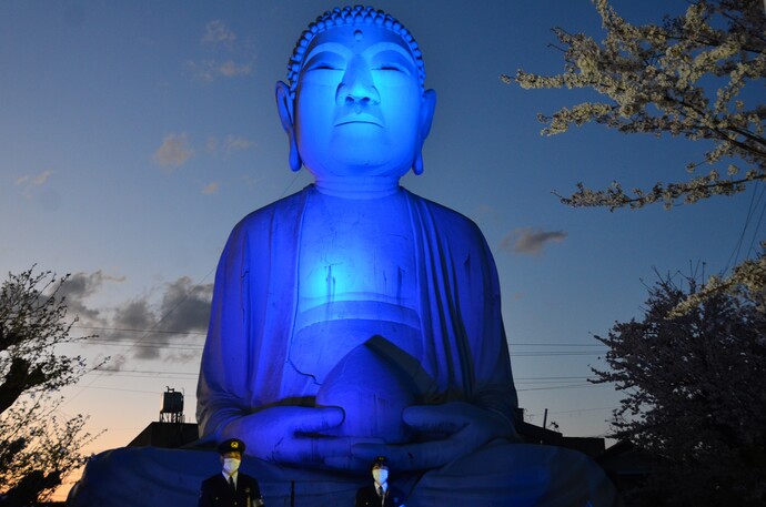 青色にライトアップされた布袋の大仏