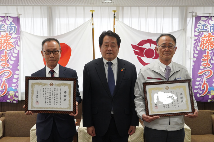 感謝状を持つ江南市災害協力会の永井会長と江南市水道工事店協同組合の祖父江代表理事と澤田市長の写真